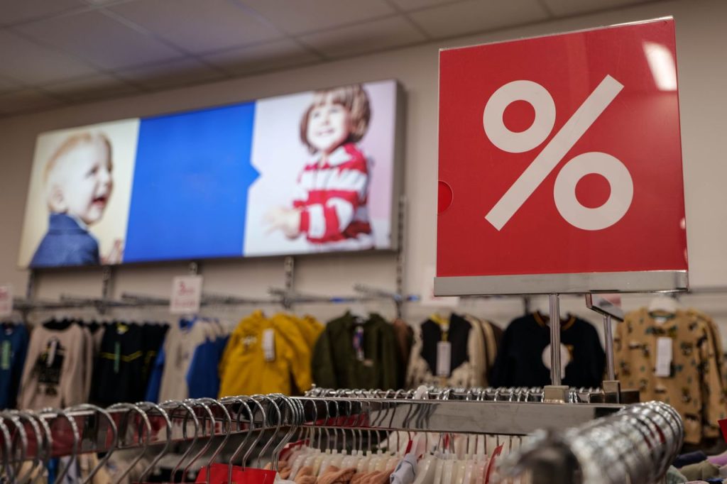 Children's clothing store with a prominent discount sign indicating a sale event.