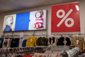Children's clothing store with a prominent discount sign indicating a sale event.
